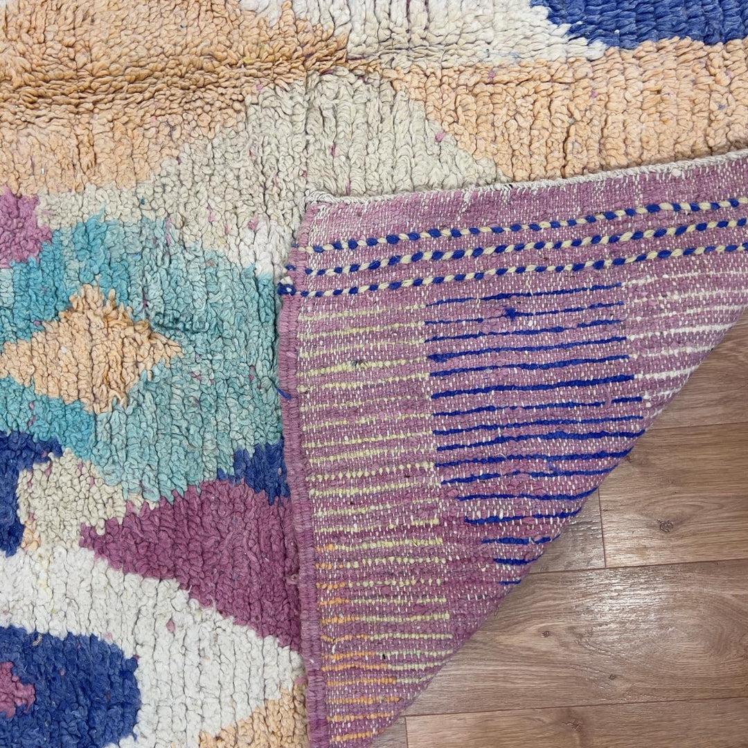 Vintage Moroccan wool rug 8.20 x 5.38 ft Rug 76 with abstract pastel design in pink, mint green, beige and blue tones, handmade Berber rug displayed on wooden floor