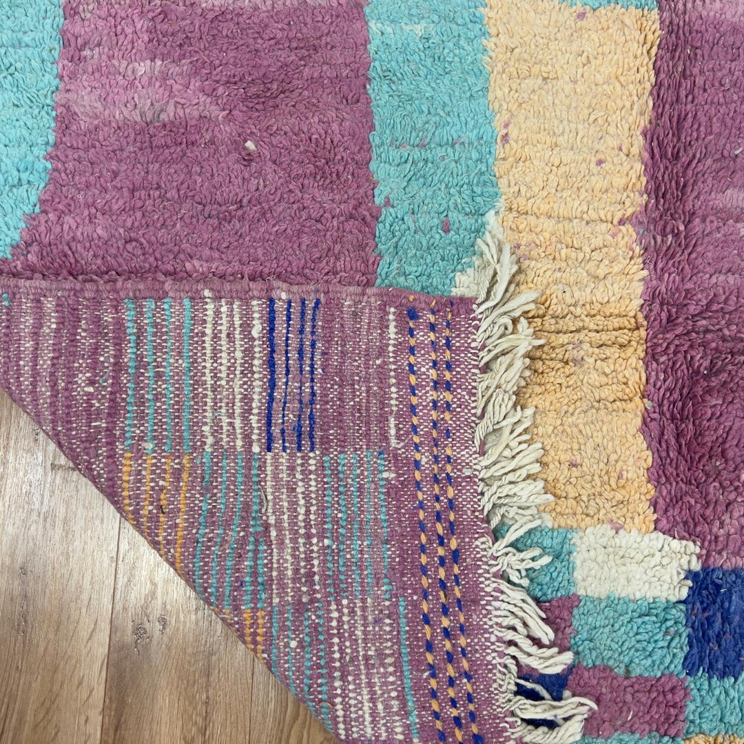 Vintage Moroccan wool rug 8.20 x 5.38 ft Rug 76 with abstract pastel design in pink, mint green, beige and blue tones, handmade Berber rug displayed on wooden floor