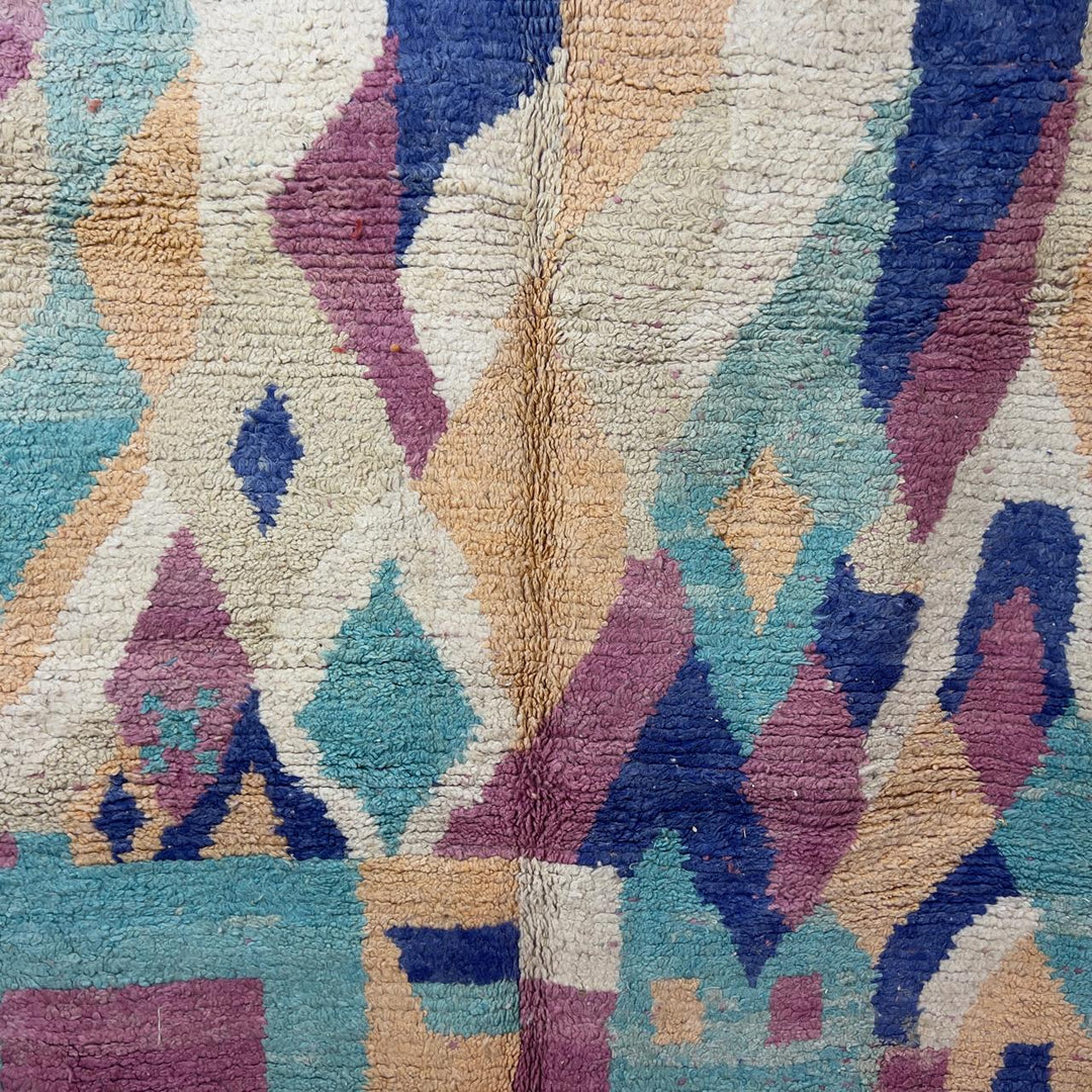 Vintage Moroccan wool rug 8.20 x 5.38 ft Rug 76 with abstract pastel design in pink, mint green, beige and blue tones, handmade Berber rug displayed on wooden floor