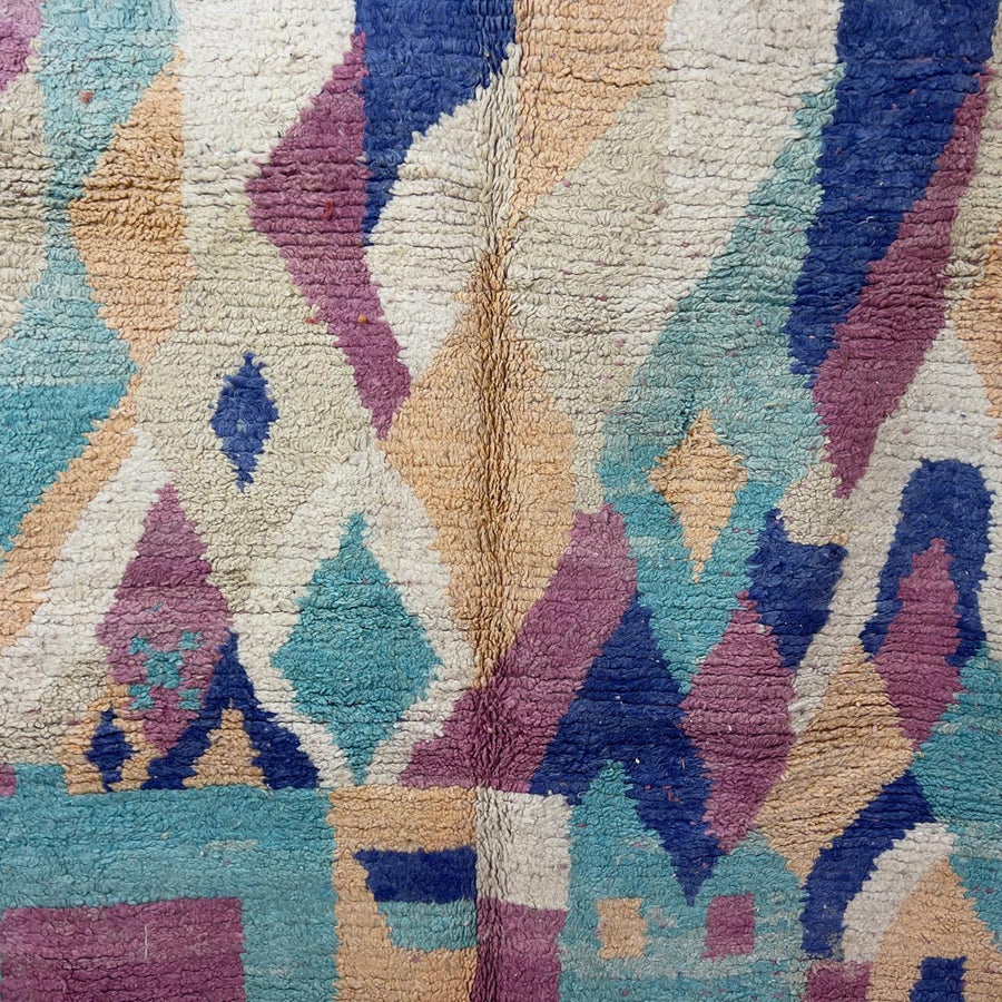 Vintage Moroccan wool rug 8.20 x 5.38 ft Rug 76 with abstract pastel design in pink, mint green, beige and blue tones, handmade Berber rug displayed on wooden floor