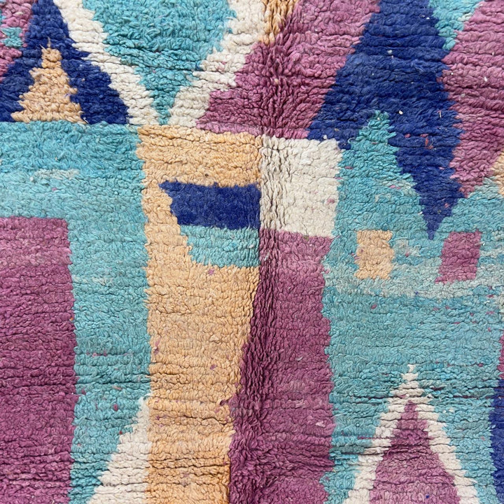 Vintage Moroccan wool rug 8.20 x 5.38 ft Rug 76 with abstract pastel design in pink, mint green, beige and blue tones, handmade Berber rug displayed on wooden floor