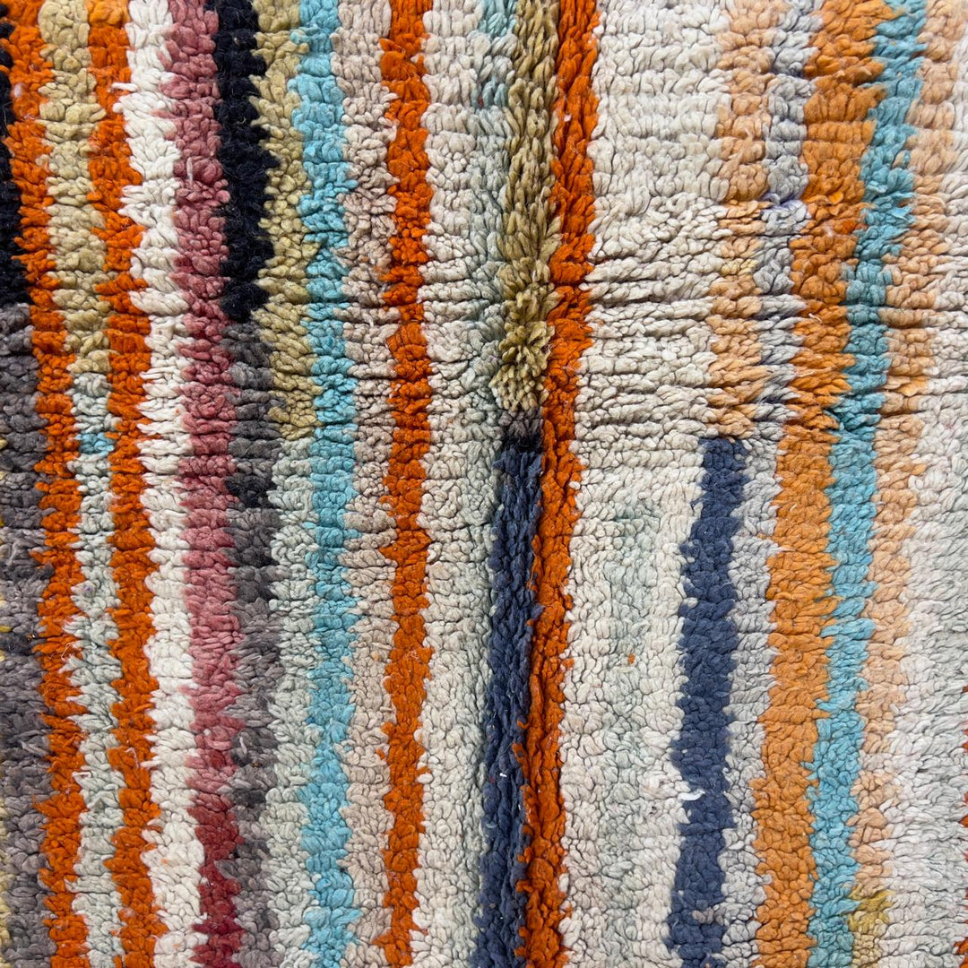 Vintage Moroccan wool rug 8.69 x 5.25 ft Rug 111 with red geometric Berber patterns and multicolor striped lower section, handmade shag rug displayed on wooden floor