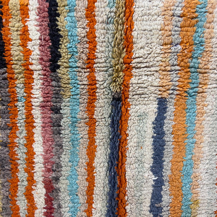 Vintage Moroccan wool rug 8.69 x 5.25 ft Rug 111 with red geometric Berber patterns and multicolor striped lower section, handmade shag rug displayed on wooden floor