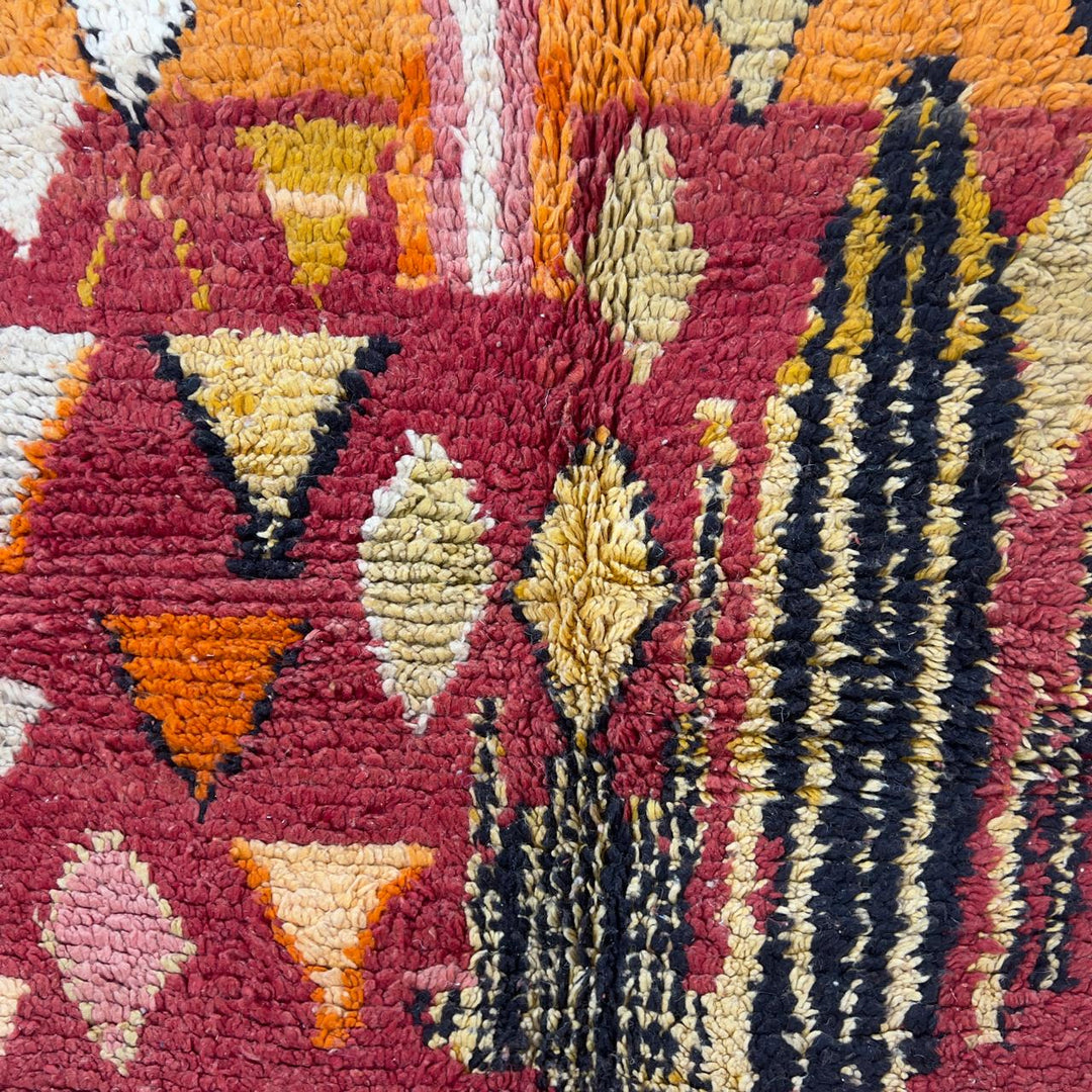 Vintage Moroccan wool rug 8.69 x 5.25 ft Rug 111 with red geometric Berber patterns and multicolor striped lower section, handmade shag rug displayed on wooden floor