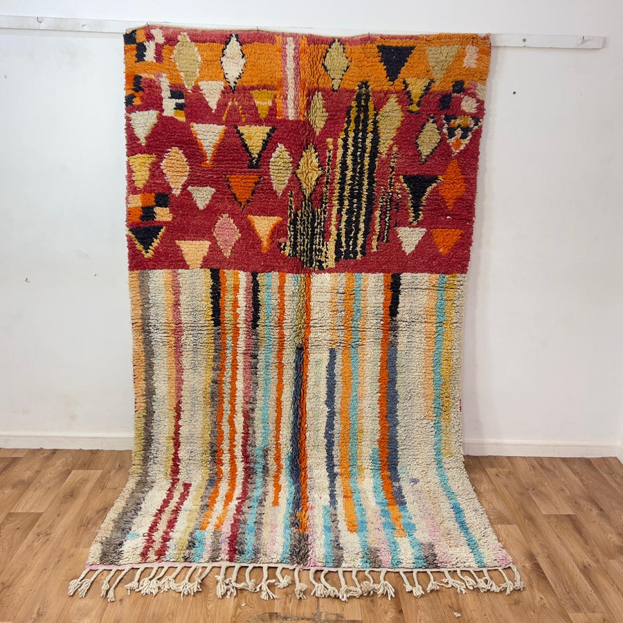 Vintage Moroccan wool rug 8.69 x 5.25 ft Rug 111 with red geometric Berber patterns and multicolor striped lower section, handmade shag rug displayed on wooden floor
