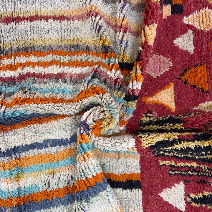 Vintage Moroccan wool rug 8.69 x 5.25 ft Rug 111 with red geometric Berber patterns and multicolor striped lower section, handmade shag rug displayed on wooden floor