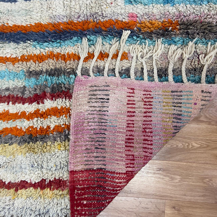 Vintage Moroccan wool rug 8.69 x 5.25 ft Rug 111 with red geometric Berber patterns and multicolor striped lower section, handmade shag rug displayed on wooden floor