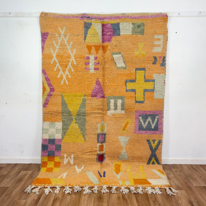Vintage Moroccan wool rug 8.0 x 5.4 ft with orange background and geometric Berber symbols in yellow purple and cream handmade rug
