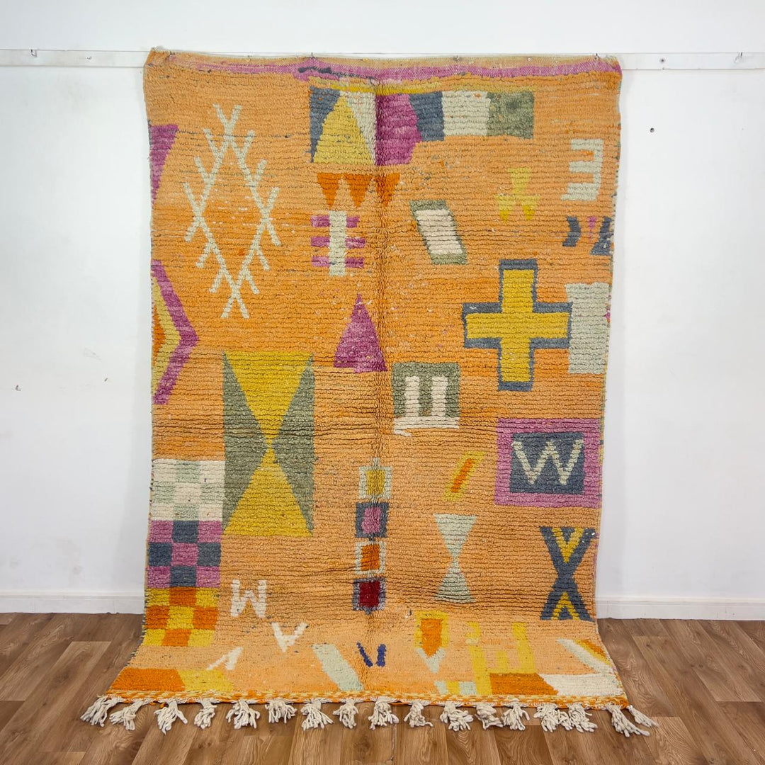 Vintage Moroccan wool rug 8.0 x 5.4 ft with orange background and geometric Berber symbols in yellow purple and cream handmade rug