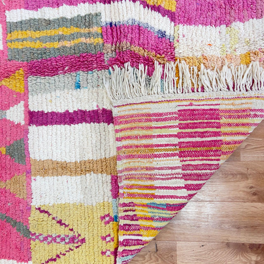 Vintage Moroccan wool rug with abstract geometric patterns in pink, blue, and yellow tones