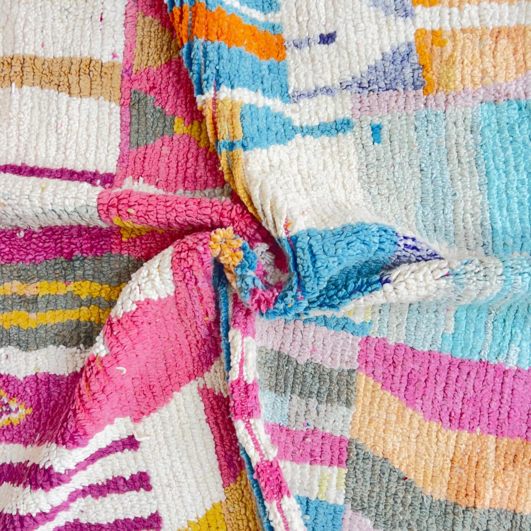 Vintage Moroccan wool rug with abstract geometric patterns in pink, blue, and yellow tones