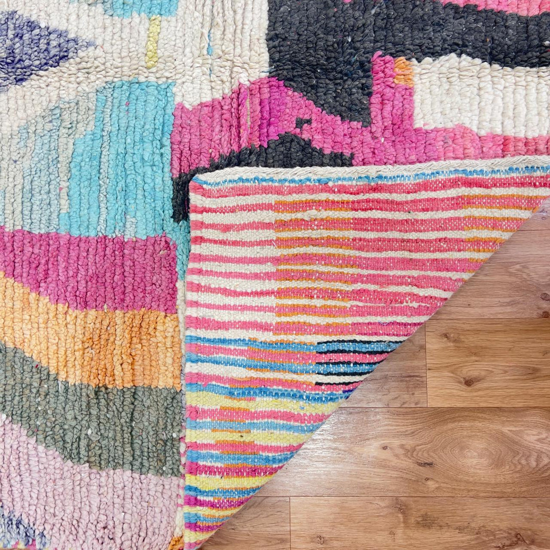 Vintage Moroccan wool rug with abstract geometric patterns in pink, blue, and yellow tones