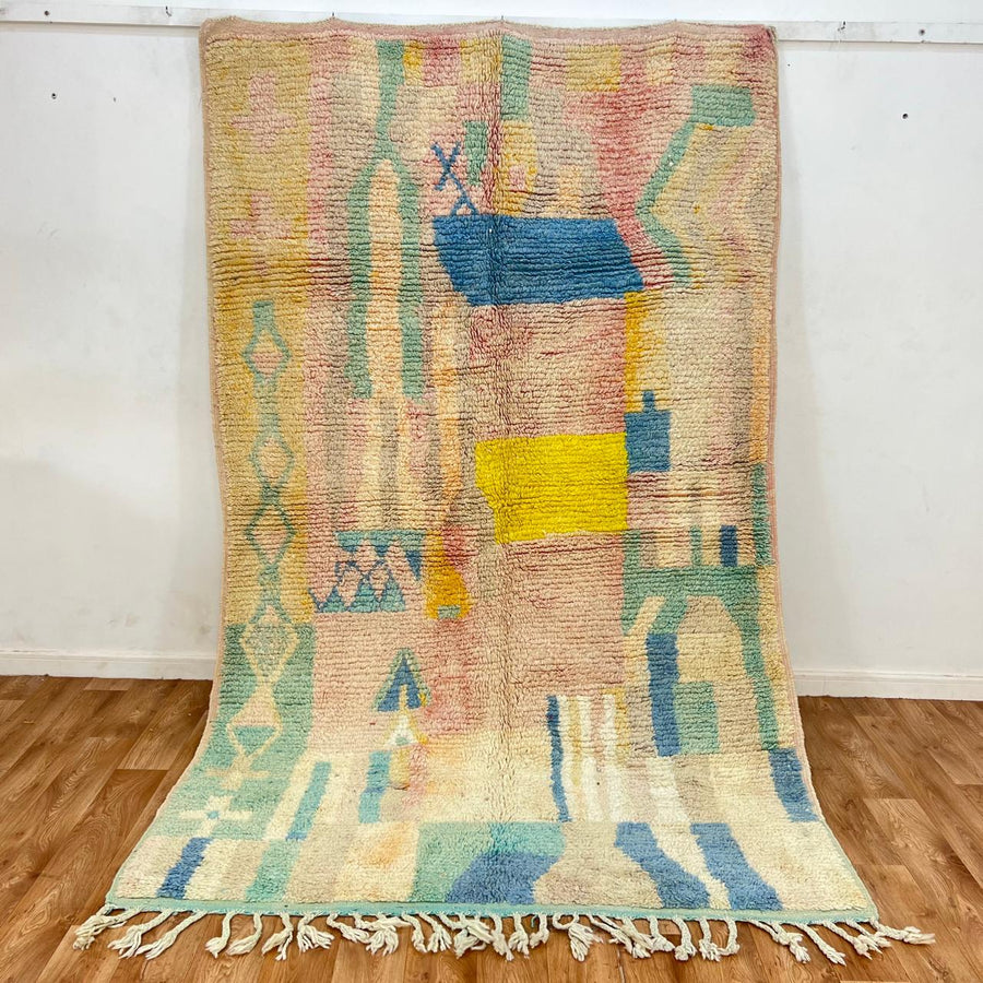 Vintage Moroccan wool rug with pastel abstract Berber motifs in blush, peach and soft blue, handmade in Morocco.