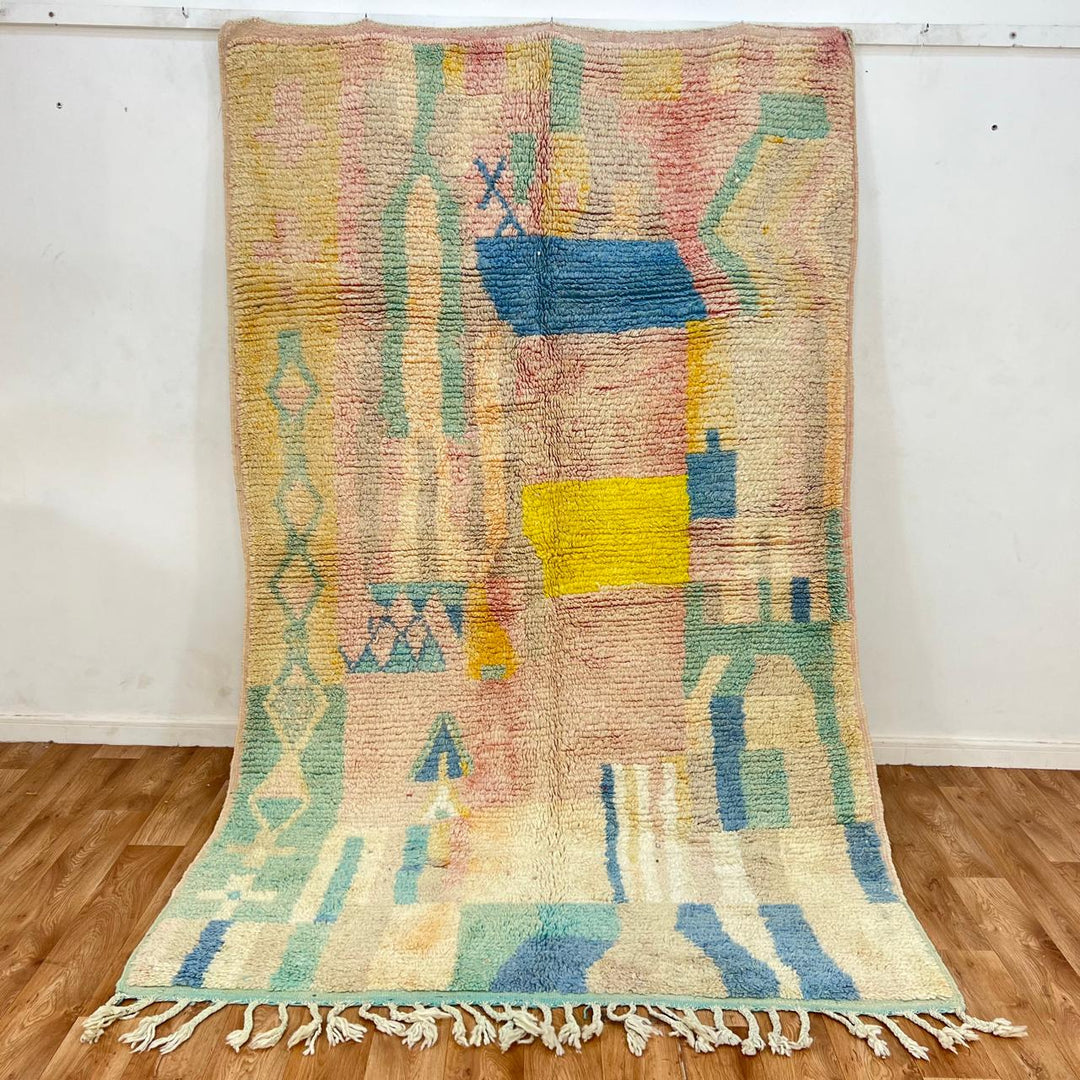 Vintage Moroccan wool rug with pastel abstract Berber motifs in blush, peach and soft blue, handmade in Morocco.