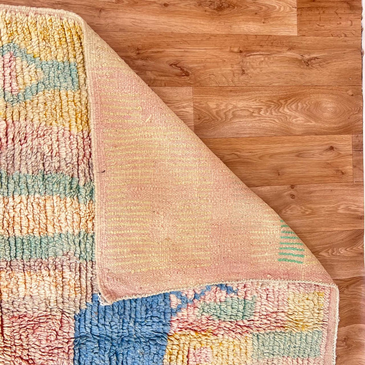Vintage Moroccan wool rug with pastel abstract Berber motifs in blush, peach and soft blue, handmade in Morocco.