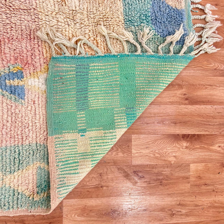 Vintage Moroccan wool rug with pastel abstract Berber motifs in blush, peach and soft blue, handmade in Morocco.