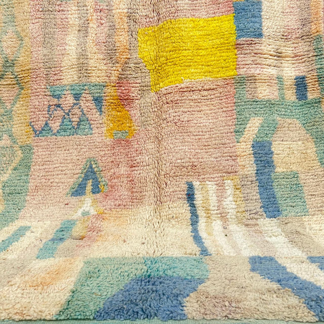 Vintage Moroccan wool rug with pastel abstract Berber motifs in blush, peach and soft blue, handmade in Morocco.