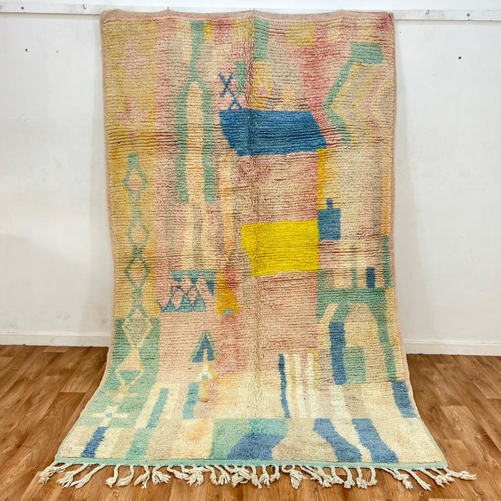 Vintage Moroccan wool rug with pastel abstract Berber motifs in blush, peach and soft blue, handmade in Morocco.