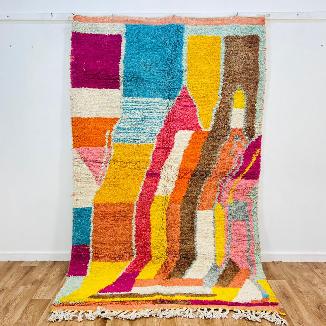 Vintage Moroccan wool rug with colorful abstract Berber pattern in yellow, pink, blue, and orange tones, handmade in Morocco
