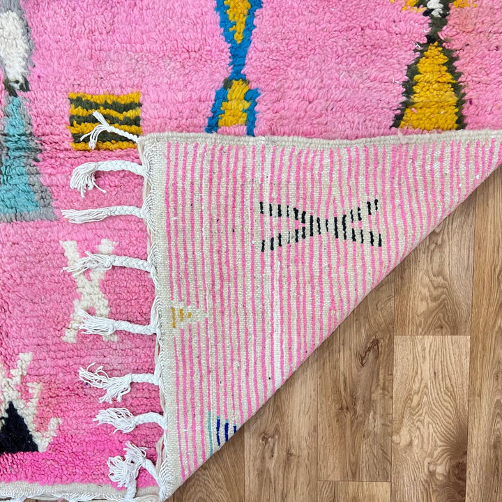 Vintage Moroccan wool rug with pink background and colorful Berber symbols, handmade in Morocco