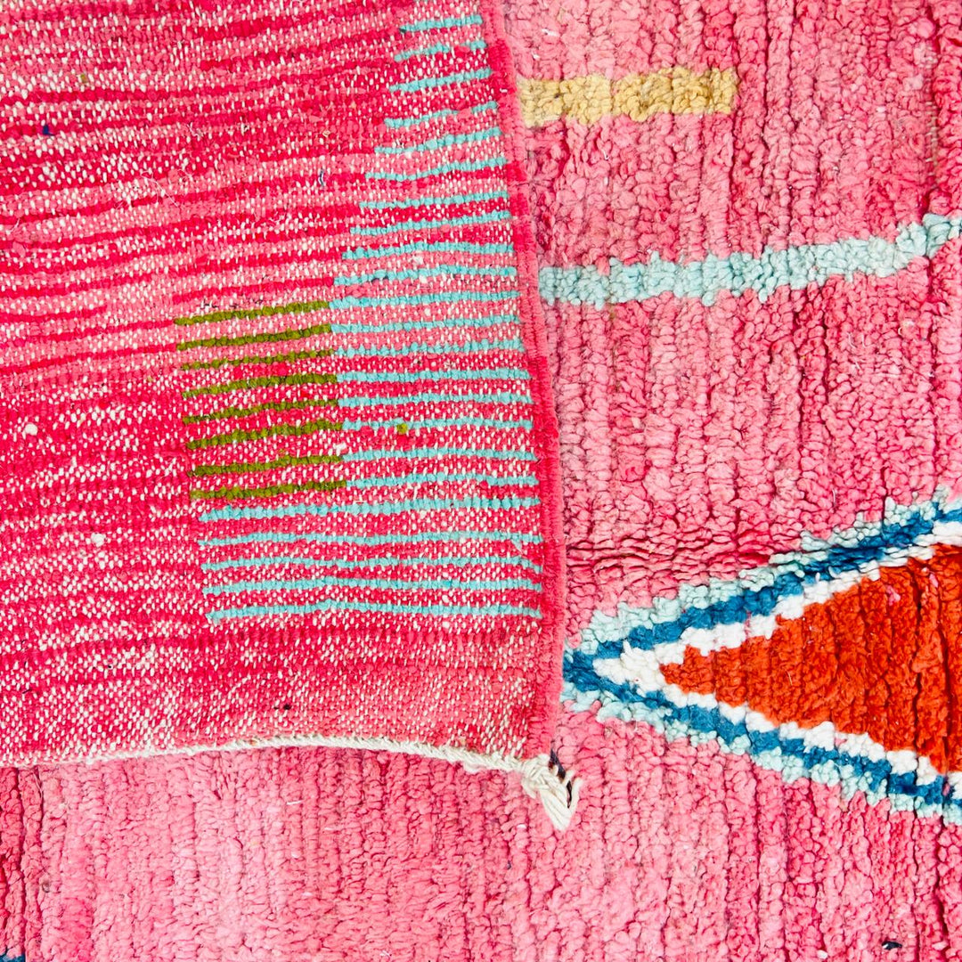 Vintage Moroccan wool rug with pink background and colorful Berber geometric symbols, handmade in Morocco