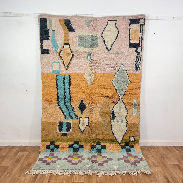 Vintage Moroccan wool rug with abstract geometric patterns in beige, mustard, and turquoise tones, handmade Berber carpet