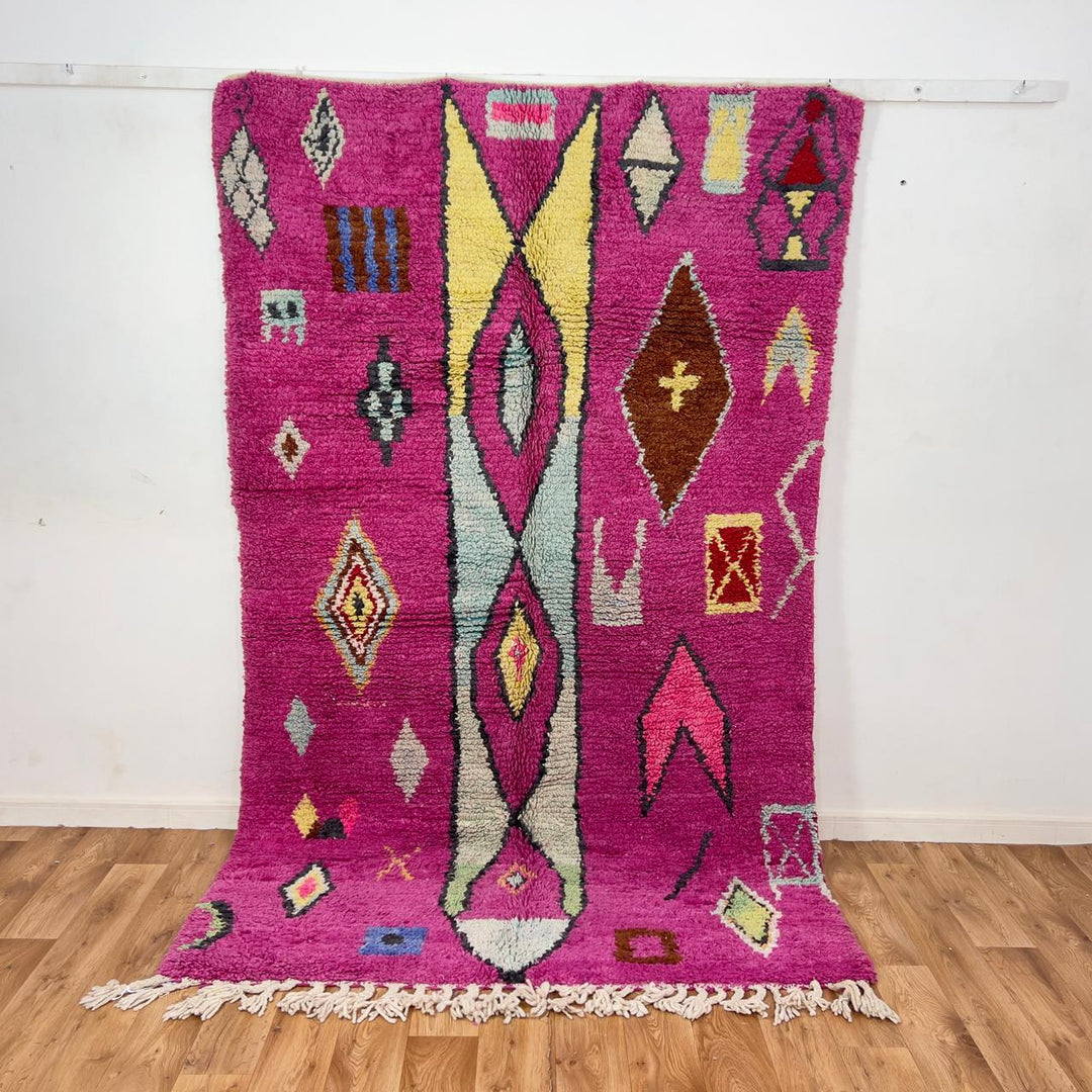 vintage moroccan wool rug with pink background and berber tribal symbols handmade shag rug