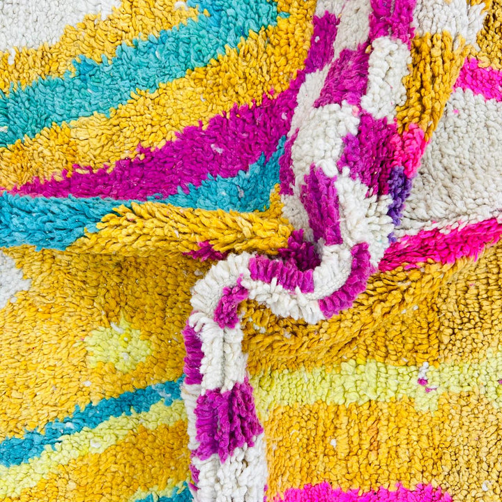 Vintage Moroccan rug with colorful Berber geometric patterns in mustard yellow, turquoise, pink, and cream wool