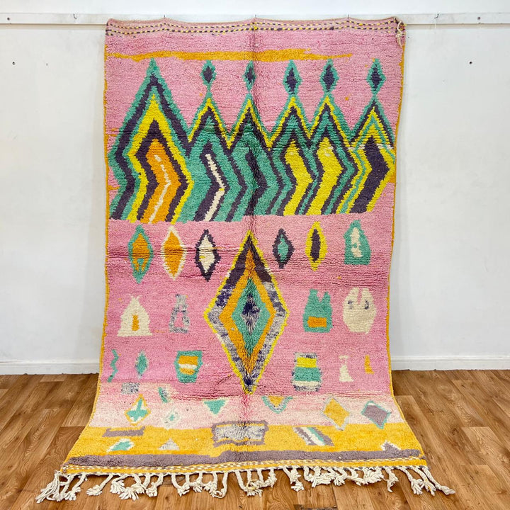 Vintage Moroccan wool rug with colorful Berber geometric pattern on pink background, 260x161 cm