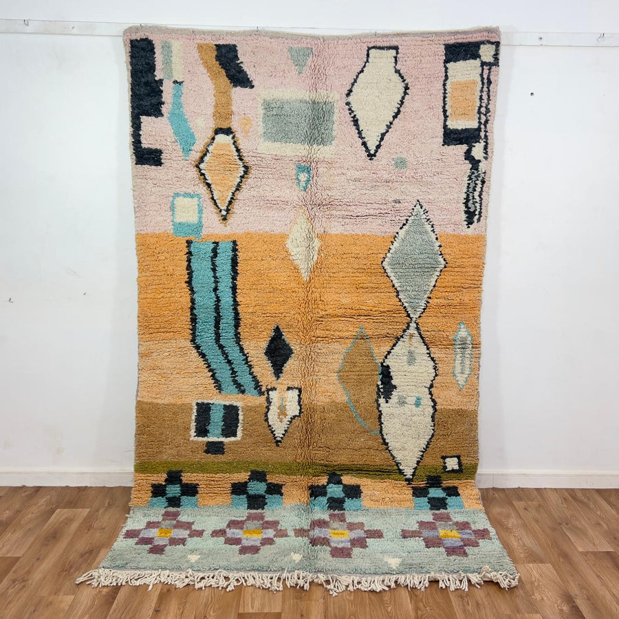 Vintage Moroccan wool rug with abstract geometric patterns in beige, mustard, and turquoise tones, handmade Berber carpet