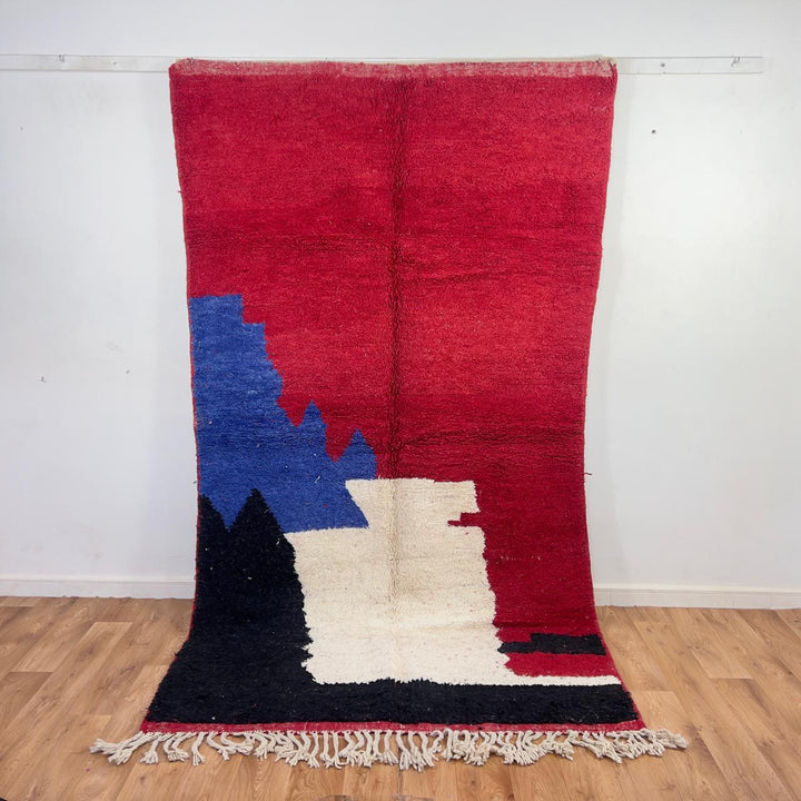 Vintage Moroccan wool rug in deep red with abstract black, ivory, and blue color blocks, handmade Berber rug