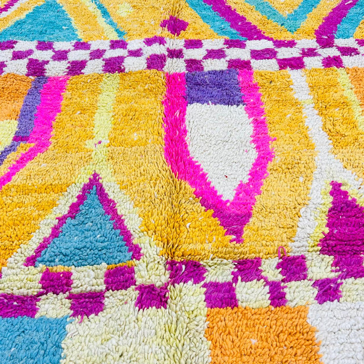 Vintage Moroccan rug with colorful Berber geometric patterns in mustard yellow, turquoise, pink, and cream wool