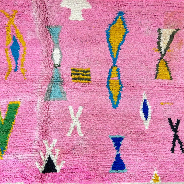 Vintage Moroccan wool rug with pink background and colorful Berber symbols, handmade in Morocco