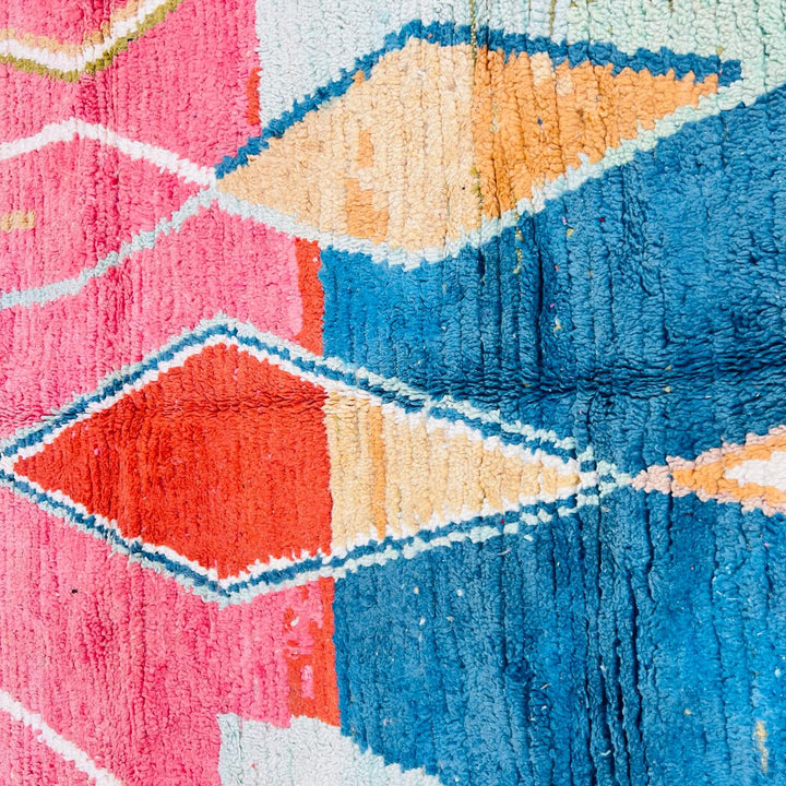 Vintage Moroccan wool rug with pink background and colorful Berber geometric symbols, handmade in Morocco