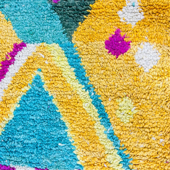 Vintage Moroccan rug with colorful Berber geometric patterns in mustard yellow, turquoise, pink, and cream wool