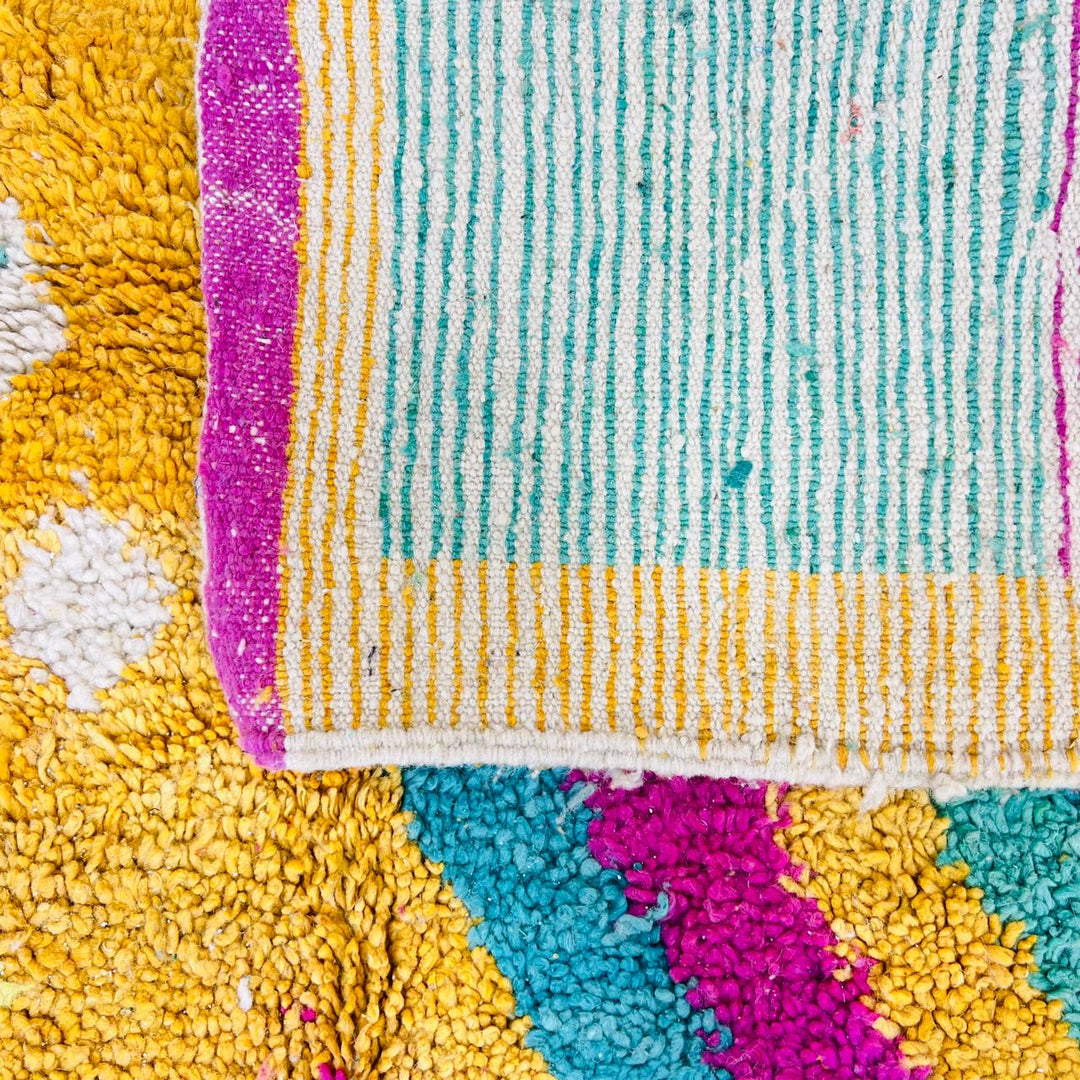Vintage Moroccan rug with colorful Berber geometric patterns in mustard yellow, turquoise, pink, and cream wool