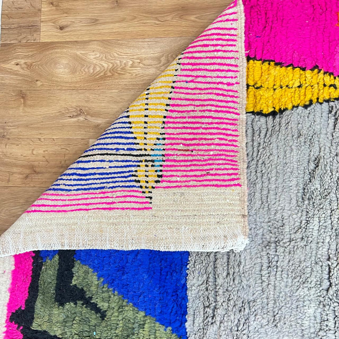 Vintage Moroccan wool rug with pink background and colorful Berber symbols, handmade in Morocco