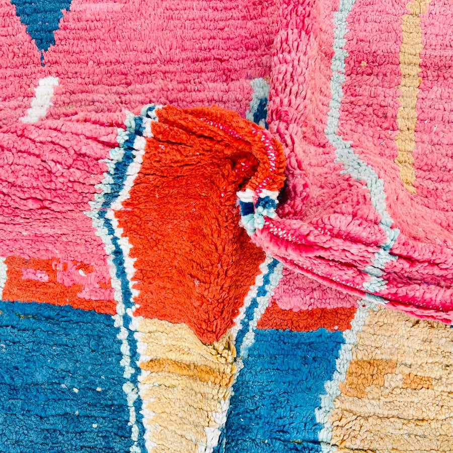 Vintage Moroccan wool rug with pink background and colorful Berber geometric symbols, handmade in Morocco