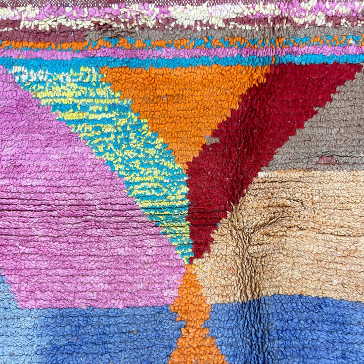 Vintage Moroccan wool rug with bold geometric Berber patterns in turquoise, red, and mustard