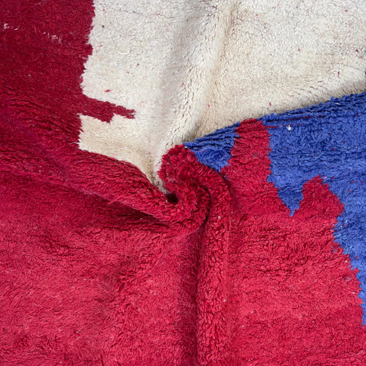 Vintage Moroccan wool rug in deep red with abstract black, ivory, and blue color blocks, handmade Berber rug