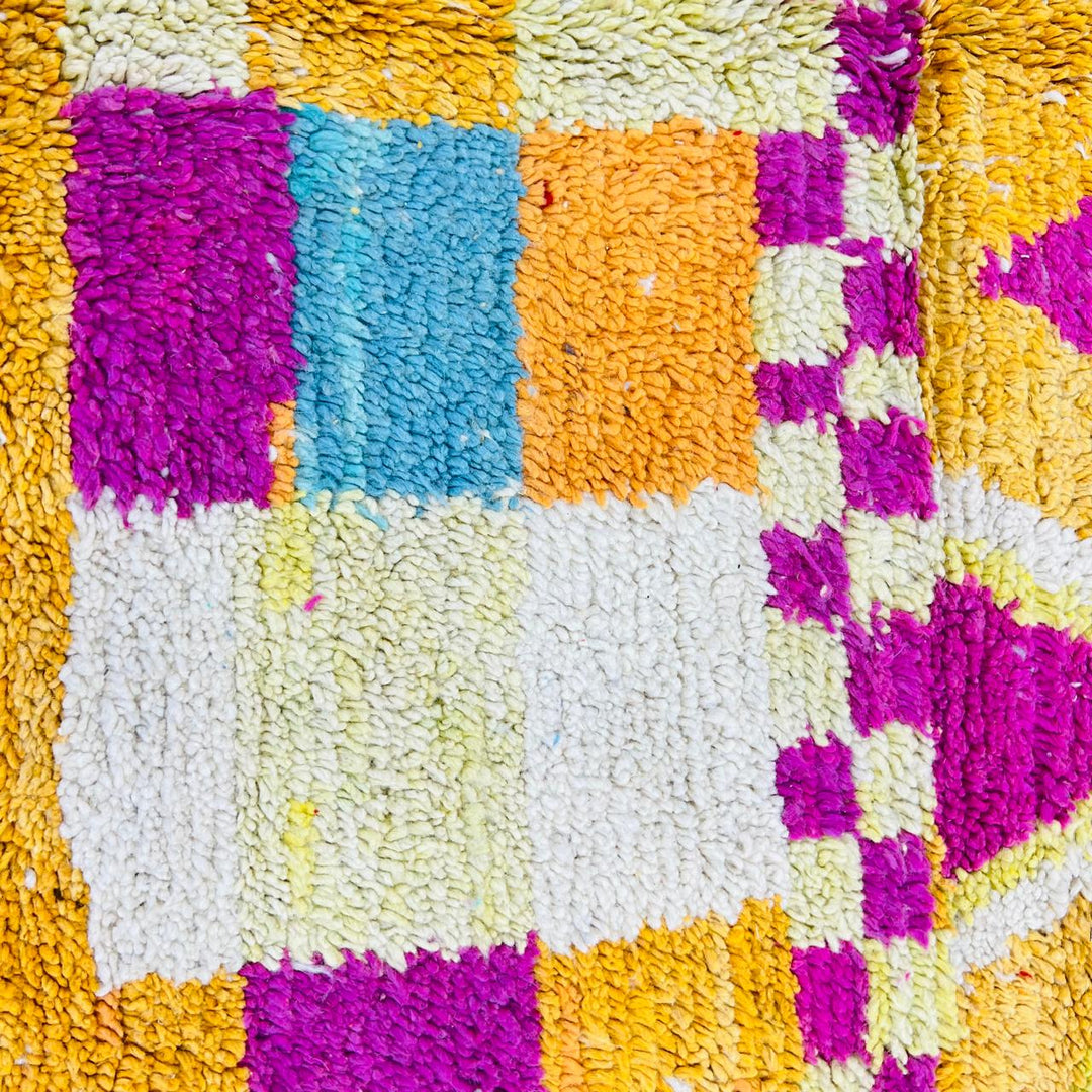 Vintage Moroccan rug with colorful Berber geometric patterns in mustard yellow, turquoise, pink, and cream wool