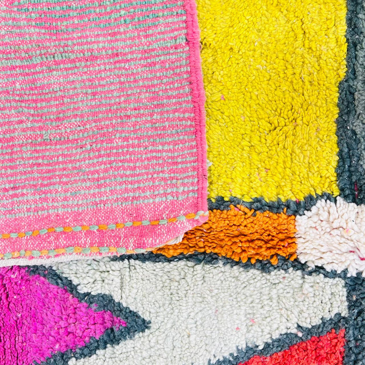 Vintage Moroccan wool rug with colorful geometric Berber pattern in pink yellow green and cream – handmade in Morocco