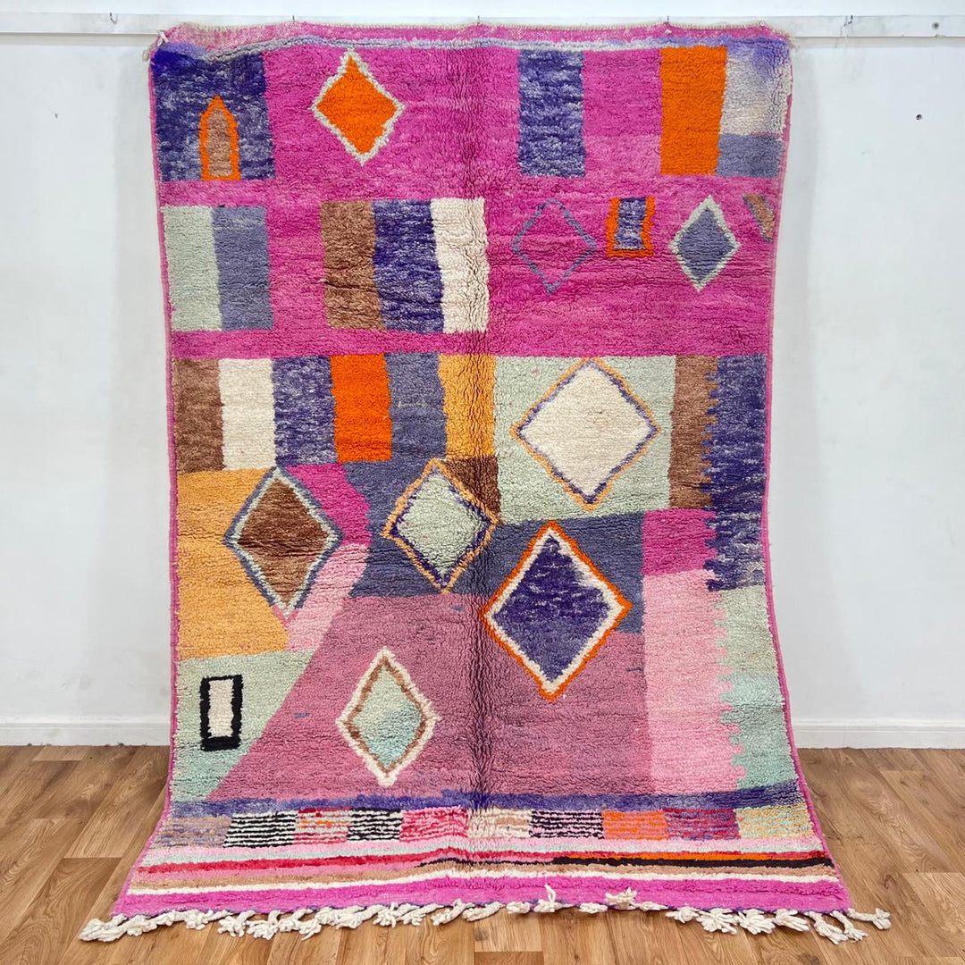 Vintage Moroccan wool rug with pink base and colorful Berber geometric diamond patterns, handmade in Morocco.