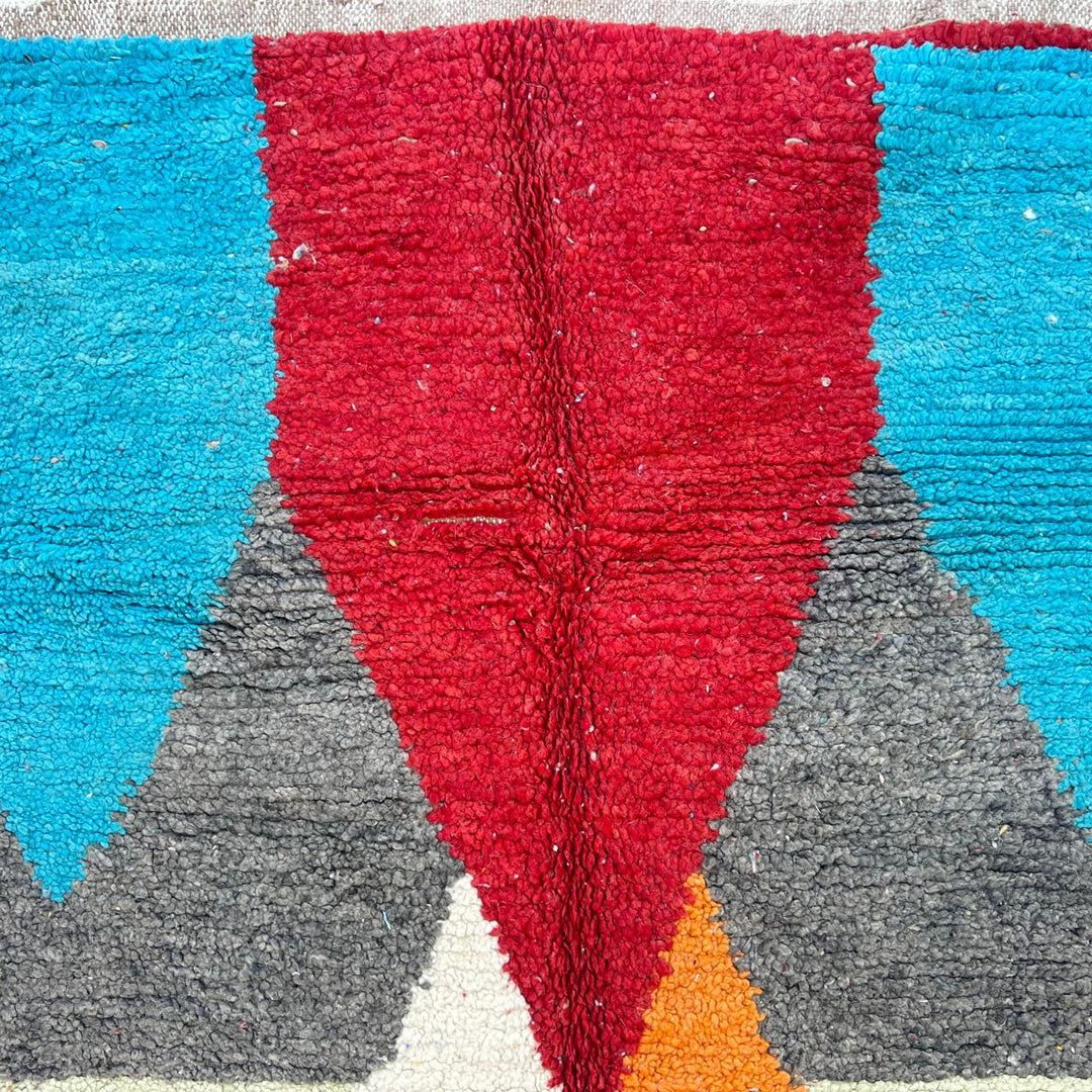 Vintage Moroccan wool rug with bold geometric Berber patterns in turquoise, red, and mustard