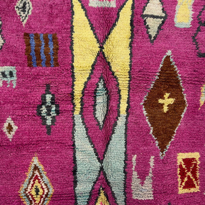 vintage moroccan wool rug with pink background and berber tribal symbols handmade shag rug