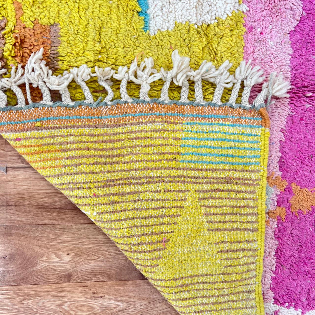 Vintage Moroccan wool rug in pink and yellow tones with abstract Berber geometric patterns, handmade in Morocco