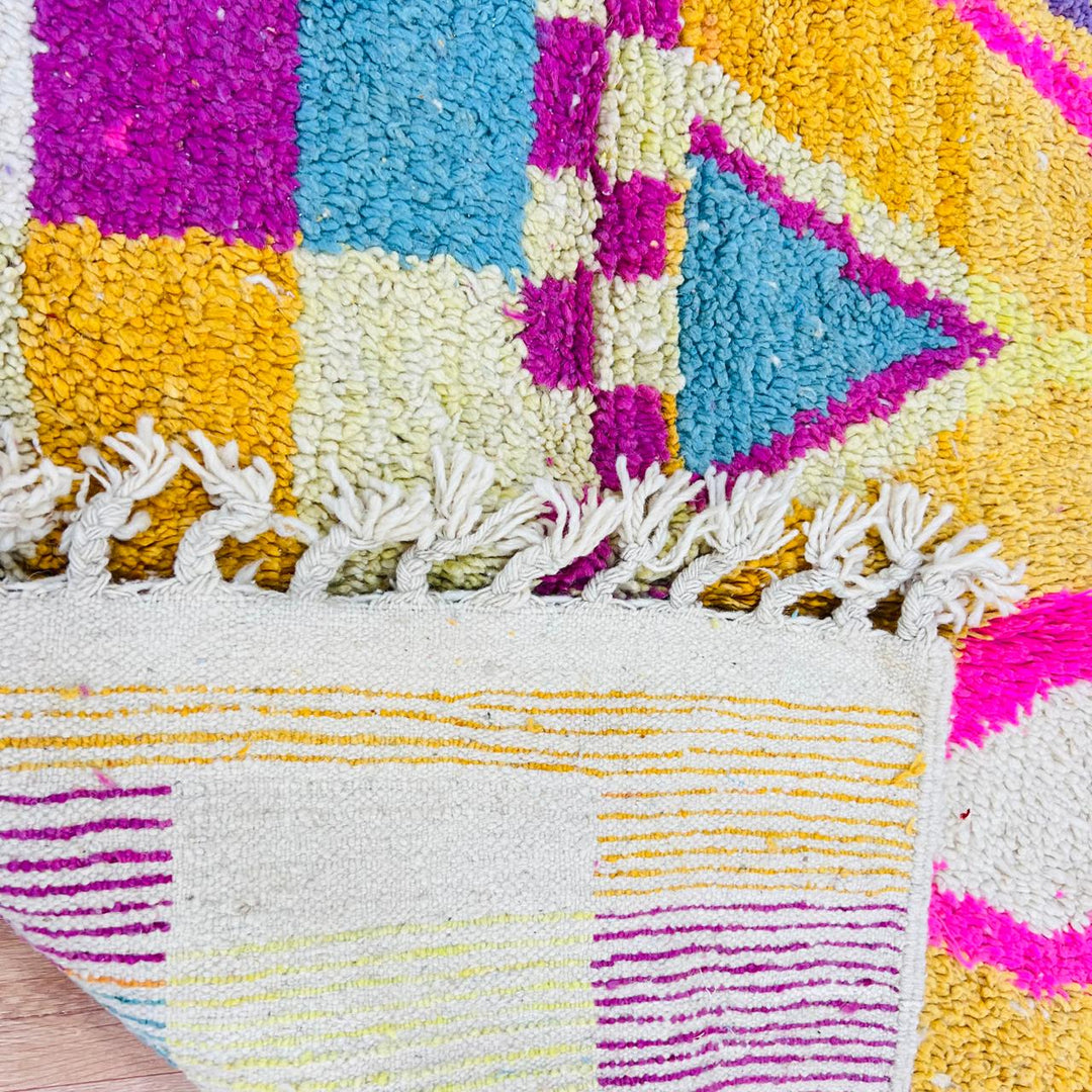 Vintage Moroccan rug with colorful Berber geometric patterns in mustard yellow, turquoise, pink, and cream wool