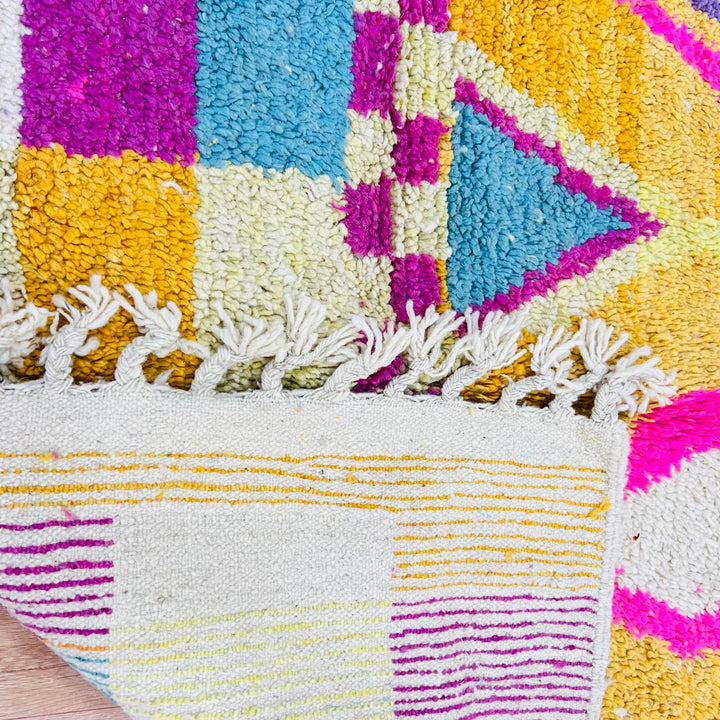 Vintage Moroccan rug with colorful Berber geometric patterns in mustard yellow, turquoise, pink, and cream wool