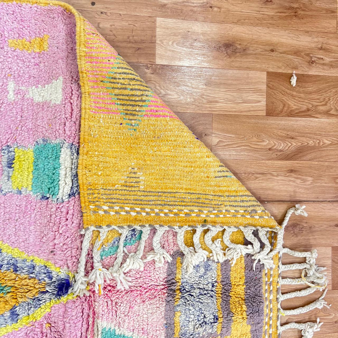 Vintage Moroccan wool rug with colorful Berber geometric pattern on pink background, 260x161 cm