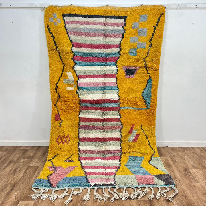 Vintage Moroccan wool rug with mustard yellow background and central striped pastel panel, abstract geometric Berber carpet 265x153 cm